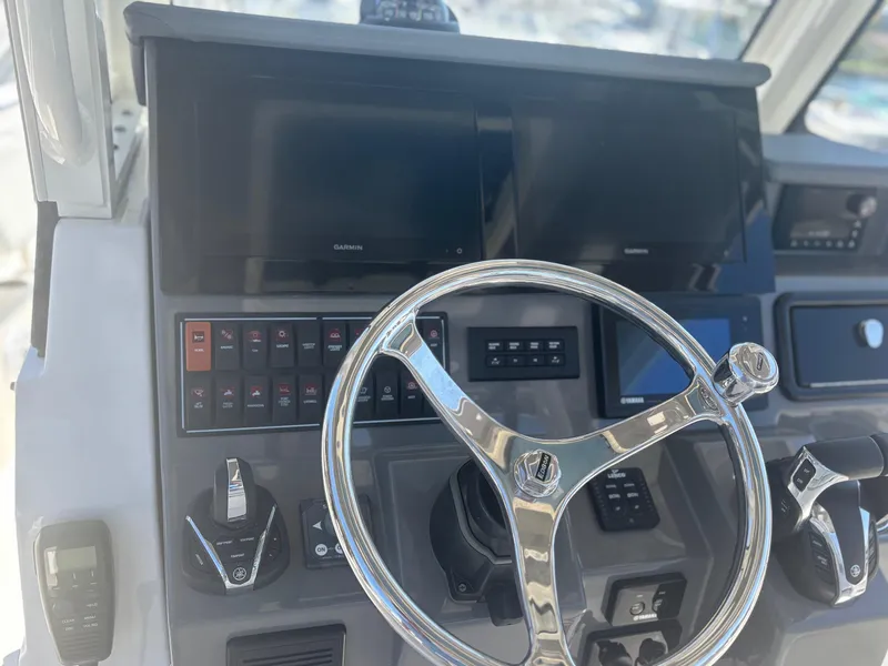 Slide: The Image of 2022 Pursuit S 288 boat dashboard with steering wheel and control panels. - 21