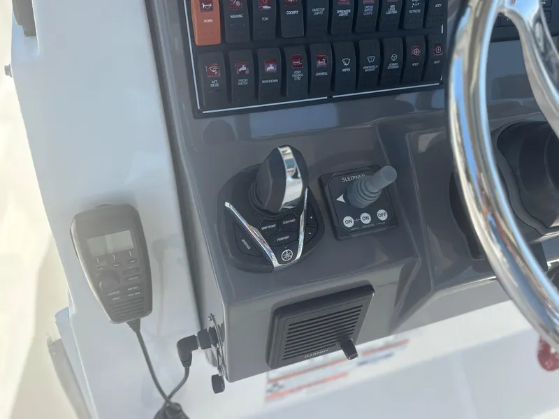 Slide: The Image of Control panel of 2022 Pursuit S 288 boat with steering wheel and joystick. - 22