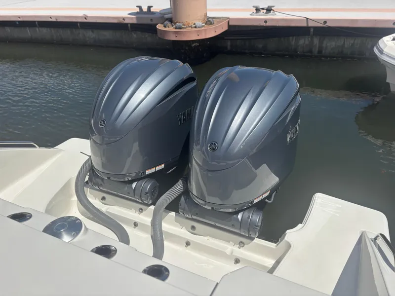 Slide: The Image of Twin outboard motors on a 2022 Pursuit S 288 boat at a dock. - 26