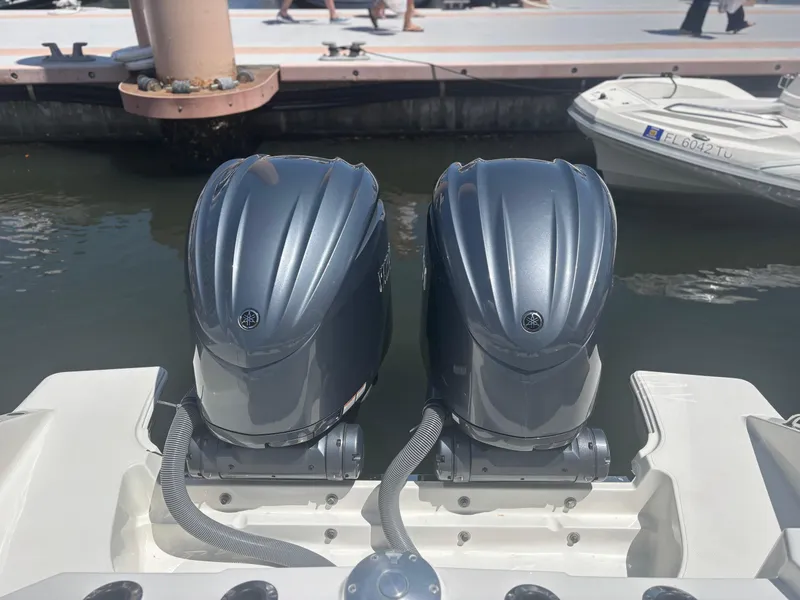 Slide: The Image of Twin outboard motors on a 2022 Pursuit S 288 boat at a marina. - 27
