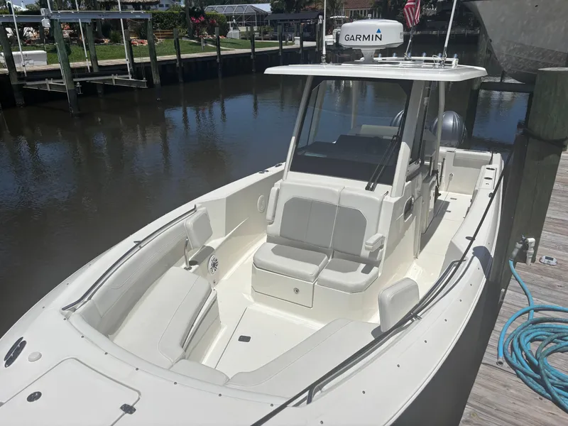 Slide: The Image of 2022 Pursuit S 288 boat docked, featuring spacious seating and Garmin equipment. - 8