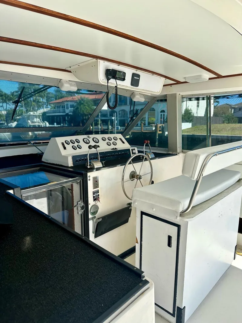 Slide: The Image of 1974 Bertram 42 Motor Yacht helm with classic controls and seating, showcasing vintage nautical design. - 13