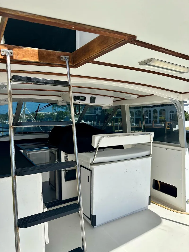 Slide: The Image of 1974 Bertram 42 Motor Yacht interior with ladder, seating, and windows. - 17