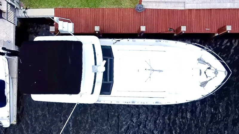 Slide: The Image of Top view of a 1974 Bertram 42 Motor Yacht docked at a wooden pier. - 2