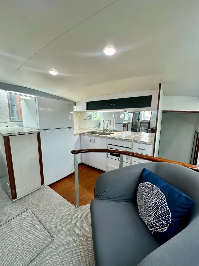 Slide: The Image of 1974 Bertram 42 Motor Yacht interior with modern kitchen and cozy seating area. - 23
