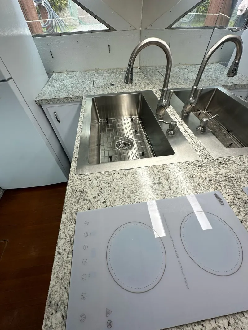 Slide: The Image of Granite countertop with dual sinks and stovetop in 1974 Bertram 42 Motor Yacht kitchen. - 29