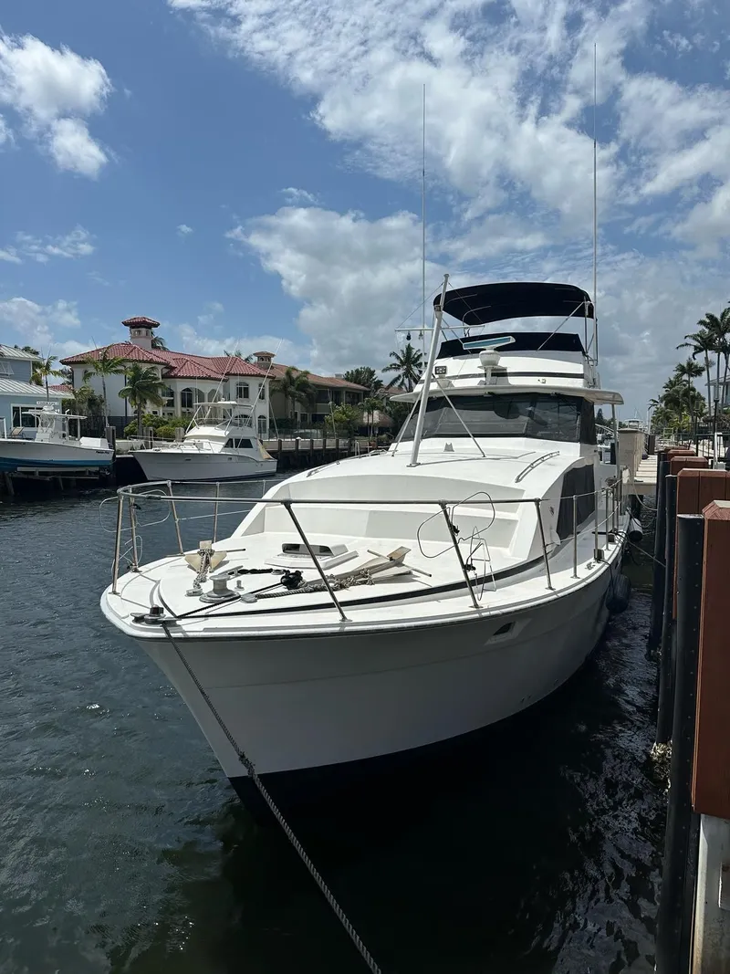 Slide: The Image of 1974 Bertram 42 Motor Yacht docked at marina under blue sky. - 5