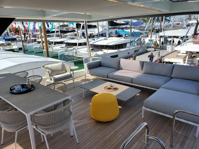 Slide: The Image of Luxurious 2020 Lagoon SEVENTY 7 yacht deck with modern seating and marina view. - 18