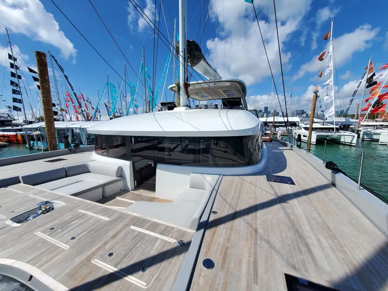 Slide: The Image of 2020 Lagoon SEVENTY 7 yacht deck with seating, docked at marina under blue sky. - 19