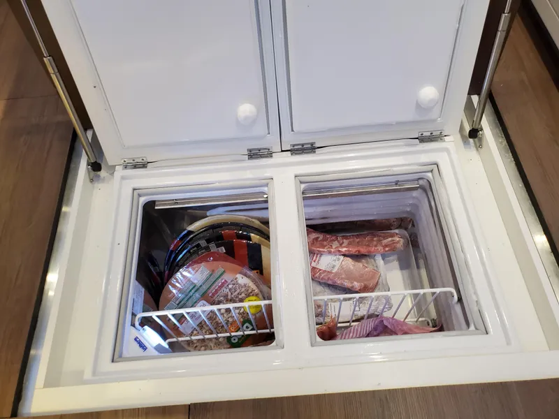 Slide: The Image of Freezer compartment on 2020 Lagoon SEVENTY 7 yacht, stocked with frozen food items. - 22