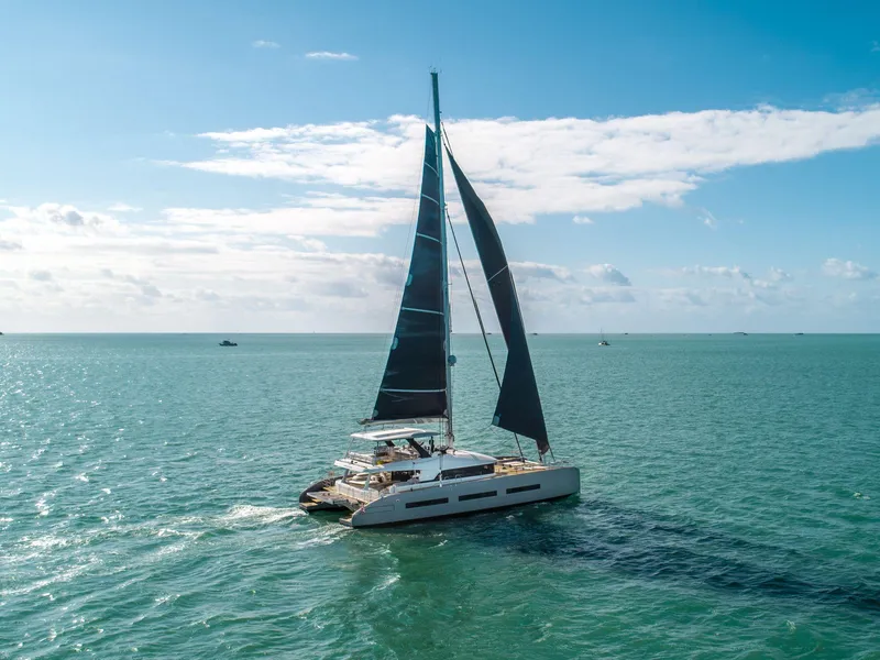 Slide: The Image of 2020 Lagoon SEVENTY 7 catamaran sailing on open sea under clear blue sky. - 30