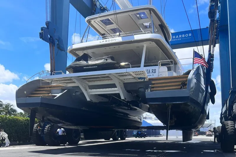 Slide: The Image of 2020 Lagoon SEVENTY 7 yacht being lifted at a marina, showcasing its sleek design. - 41