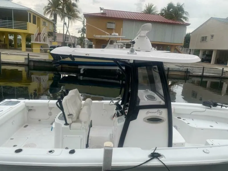 Slide: The Image of 2018 Sea Hunt Gamefish 27 boat docked near waterfront homes, featuring a sleek design. - 10