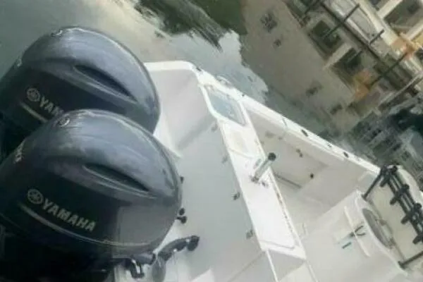 Slide: The Image of 2018 Sea Hunt Gamefish 27 boat with dual Yamaha engines docked by the water. - 15