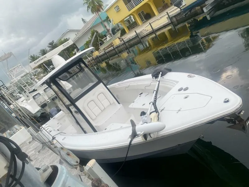 Slide: The Image of 2018 Sea Hunt Gamefish 27 boat docked in a marina, surrounded by calm water. - 4