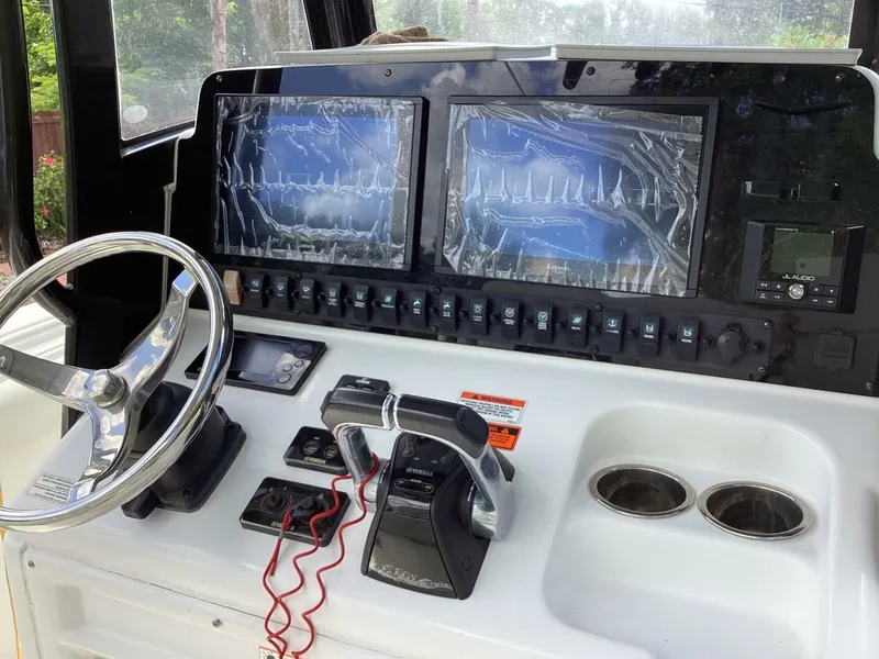 Slide: The Image of Control panel of a 2018 Sea Hunt Gamefish 27 boat with dual screens and steering wheel. - 48
