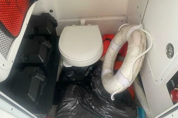 Slide: The Image of Interior of 2018 Sea Hunt Gamefish 27 with toilet, life preserver, and storage compartments. - 79