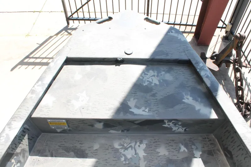 Slide: The Image of 2025 War Eagle 750 Gladiator boat with camouflage pattern, docked near a metal fence. - 4