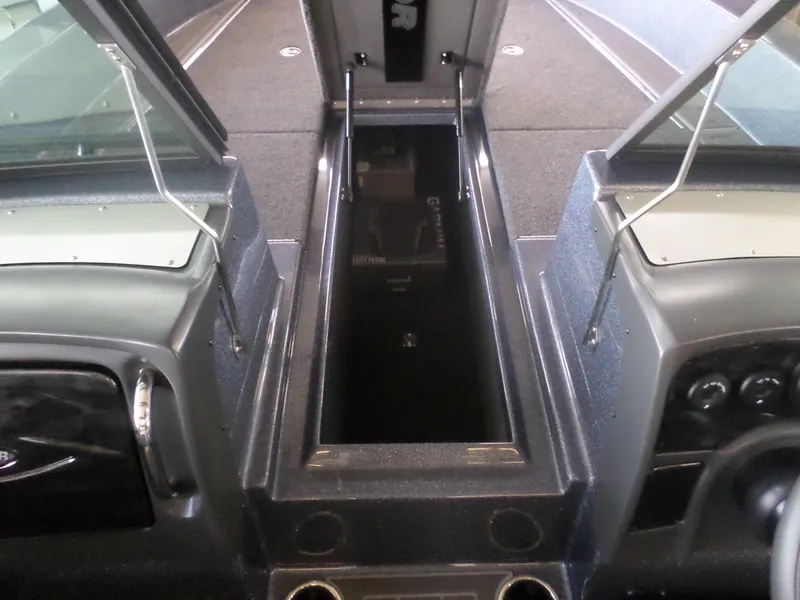 Slide: The Image of 2025 Warrior 238 DC boat interior with open storage compartment and dashboard view. - 12