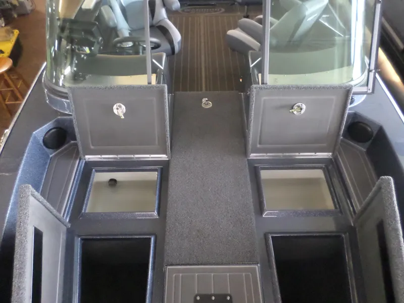 Slide: The Image of 2025 Warrior 238 DC boat interior with open storage compartments and seating. - 4