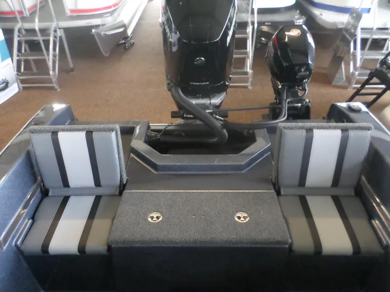 Slide: The Image of 2025 Warrior 238 DC boat interior with dual seating and outboard motor. - 7