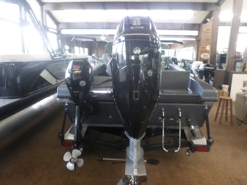 Slide: The Image of 2025 Warrior 238 DC boat with dual outboard motors in showroom. - 8