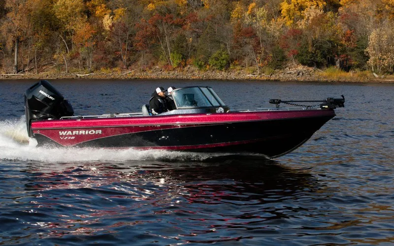 Slide: The Image of 2025 Warrior 238 DC boat cruising on a lake with autumn foliage in the background. - 9