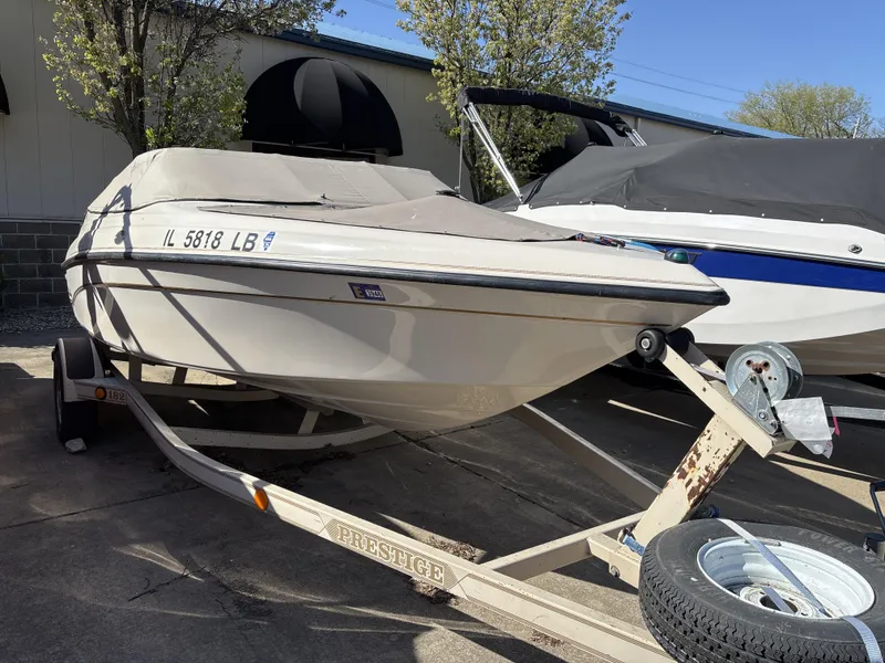 Slide: The Image of 1996 Crownline 182 BR boat on trailer, covered and parked outdoors. - 2