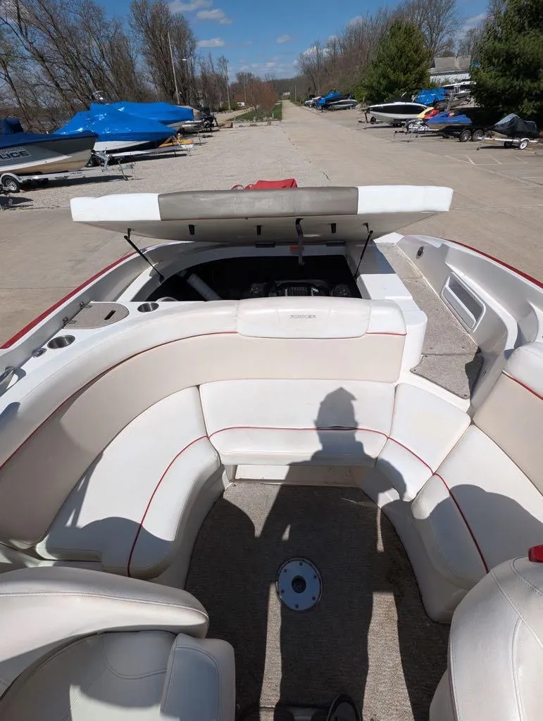 Slide: The Image of 2006 Rinker Captiva 226 boat interior with open engine compartment, parked outdoors. - 2