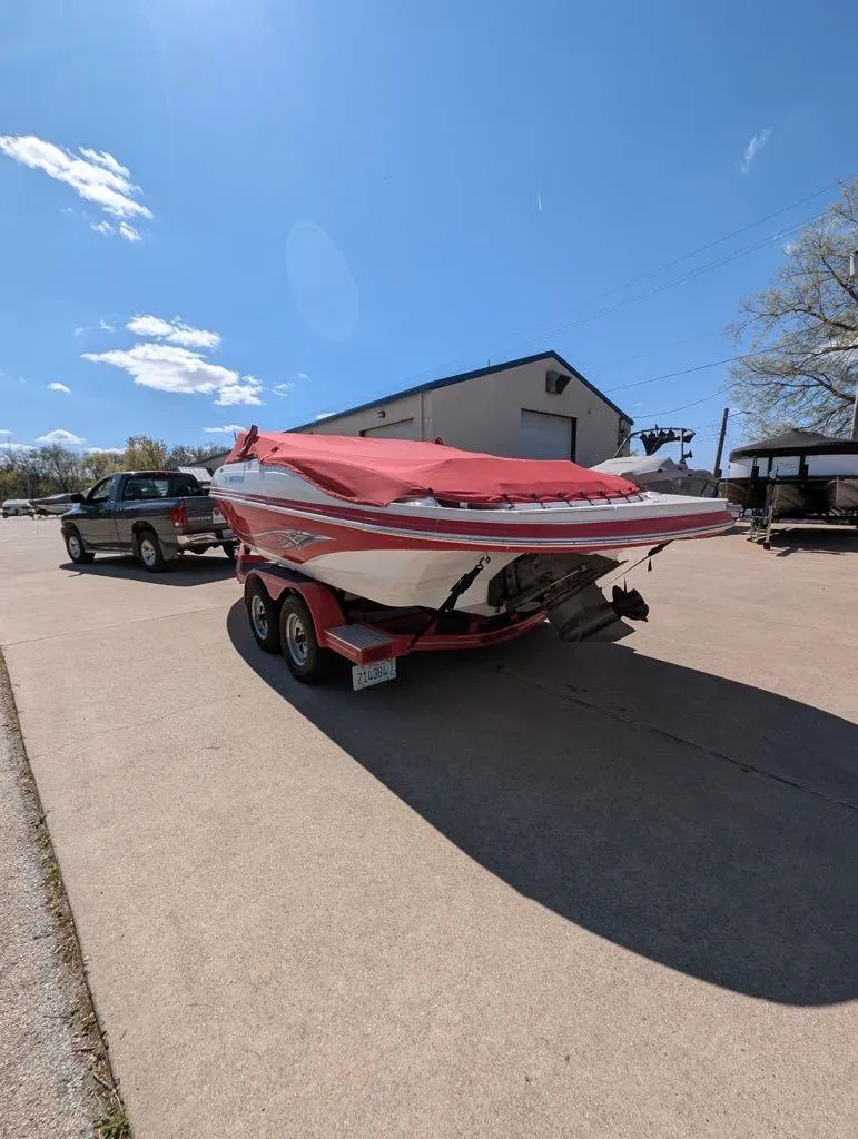 Slide: The Image of 2006 Rinker Captiva 226 boat on trailer, covered, parked outdoors under clear sky. - 6