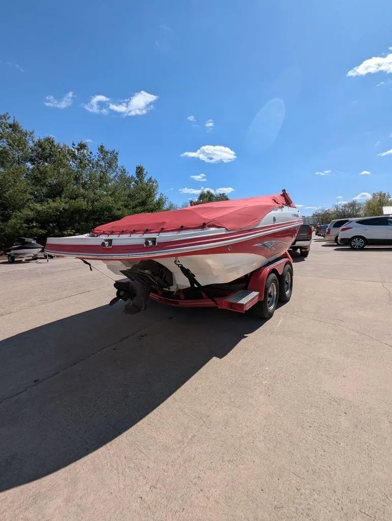 Slide: The Image of 2006 Rinker Captiva 226 boat on trailer with red cover, parked outdoors. - 9