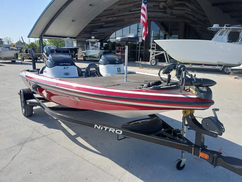 Slide: The Image of Red 2015 Nitro Z7 boat on trailer, parked outside a modern building. - 3