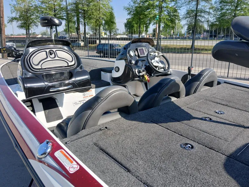 Slide: The Image of 2015 Nitro Z7 boat interior with steering console and seating, parked outdoors. - 7