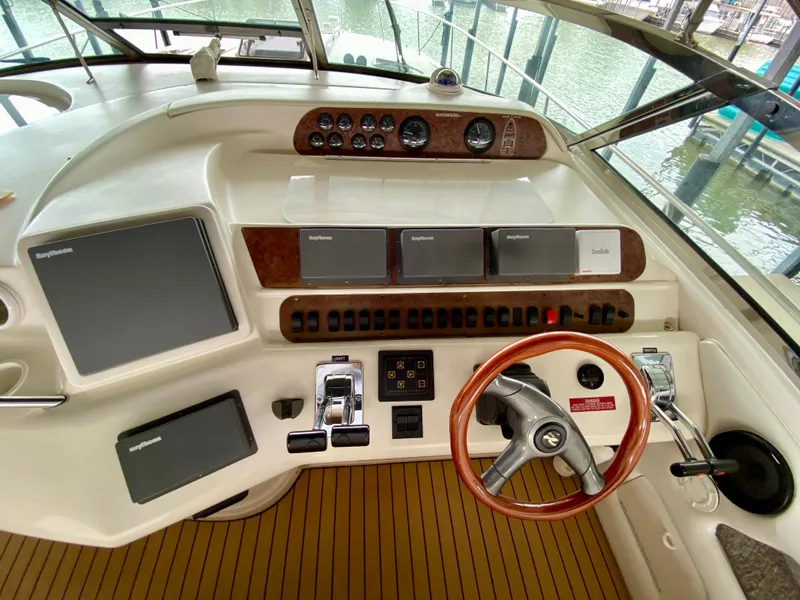 Slide: The Image of Helm of 1996 Sea Ray 450 Sundancer with wood accents and modern navigation equipment. - 13