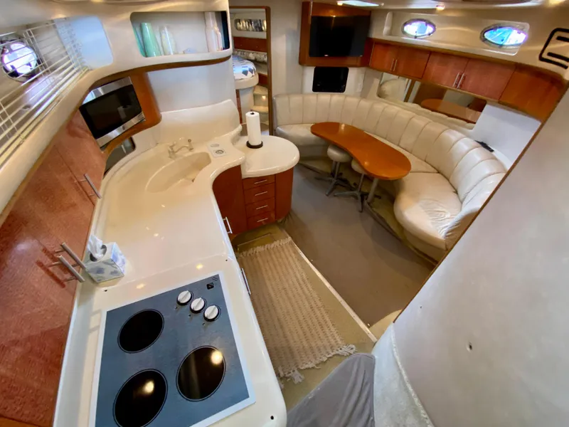 Slide: The Image of Interior of 1996 Sea Ray 450 Sundancer yacht with kitchen and dining area. - 15