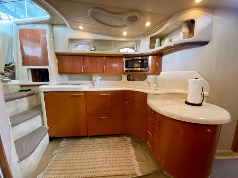 Slide: The Image of Interior of 1996 Sea Ray 450 Sundancer yacht kitchen with wood cabinets and modern appliances. - 16