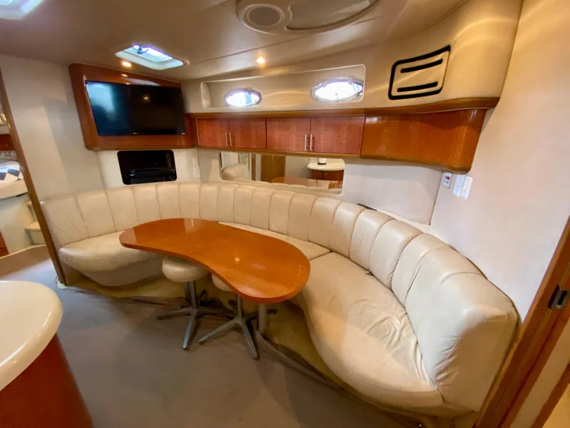 Slide: The Image of Luxurious interior of 1996 Sea Ray 450 Sundancer with curved seating and wooden table. - 17