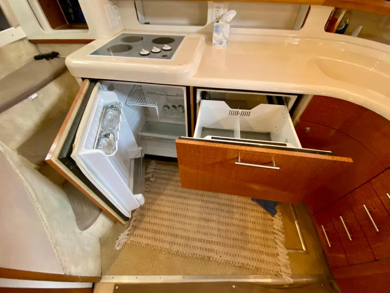 Slide: The Image of Interior of a 1996 Sea Ray 450 Sundancer showing kitchen with open fridge and drawers. - 18