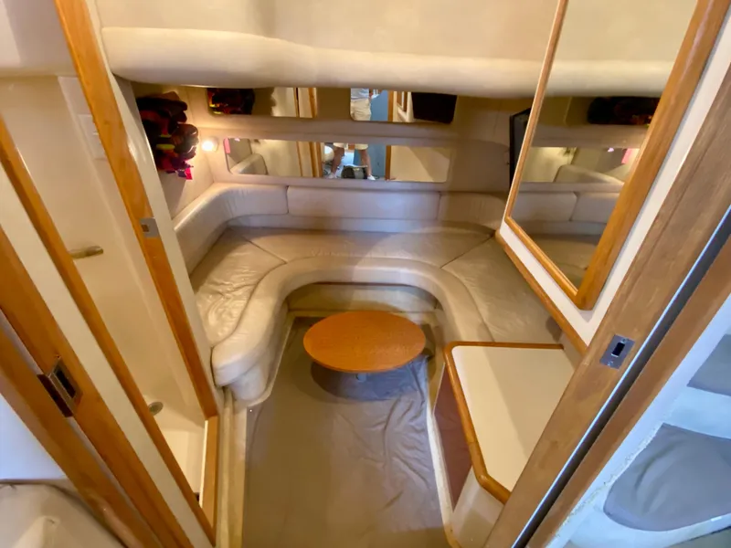 Slide: The Image of 1996 Sea Ray 450 Sundancer interior with cozy seating and wooden accents. - 22
