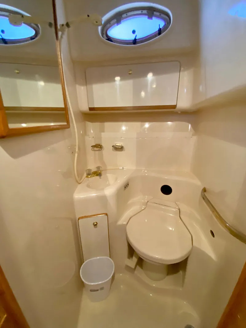 Slide: The Image of Bathroom interior of 1996 Sea Ray 450 Sundancer yacht, featuring compact design and porthole window. - 25
