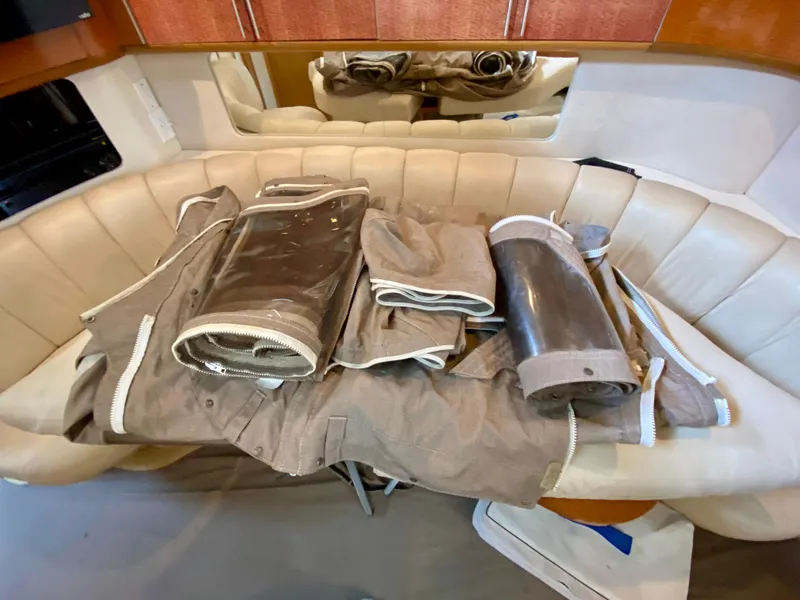 Slide: The Image of 1996 Sea Ray 450 Sundancer interior with beige seating and rolled canvas covers. - 38