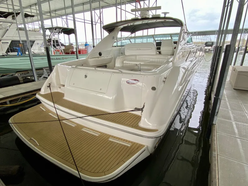 Slide: The Image of 1996 Sea Ray 450 Sundancer yacht docked in marina, showcasing sleek design and spacious deck. - 4