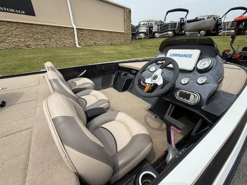 Slide: The Image of Interior of a 2014 Nitro Z-7 boat with steering wheel and beige seats. - 2