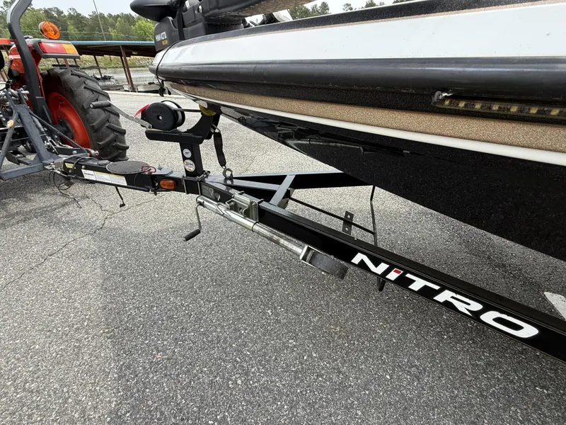 Slide: The Image of 2014 Nitro Z-7 boat trailer hitched to a tractor on asphalt. - 5