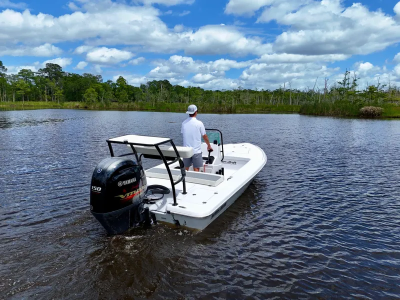Slide: The Image of 2025 Action Craft 17 Flats boat on a serene lake with lush greenery. - 10