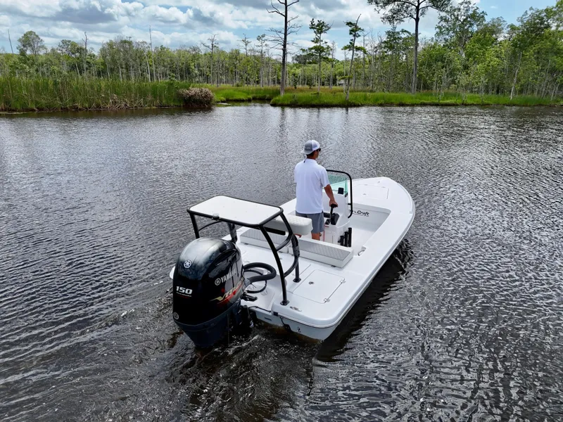 Slide: The Image of 2025 Action Craft 17 Flats boat navigating a serene river with lush greenery. - 12