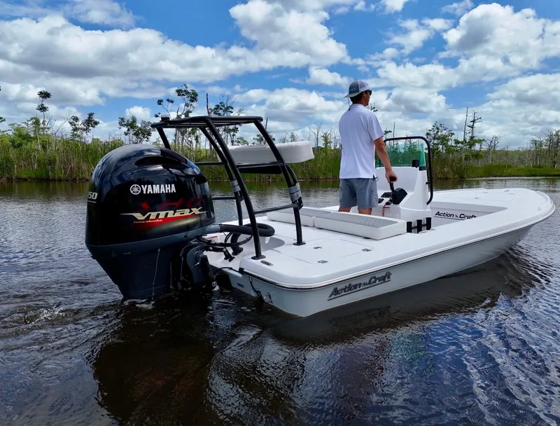Slide: The Image of 2025 Action Craft 17 Flats boat with Yamaha VMAX engine on a calm waterway. - 2