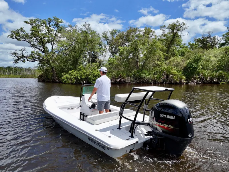 Slide: The Image of 2025 Action Craft 17 Flats boat on a scenic river with lush greenery. - 5