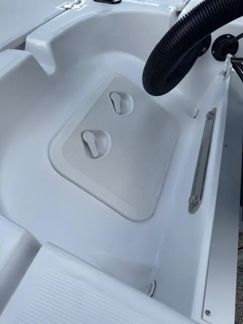 Slide: The Image of 2025 Action Craft 17 Flats boat interior with storage compartment and steering wheel. - 64