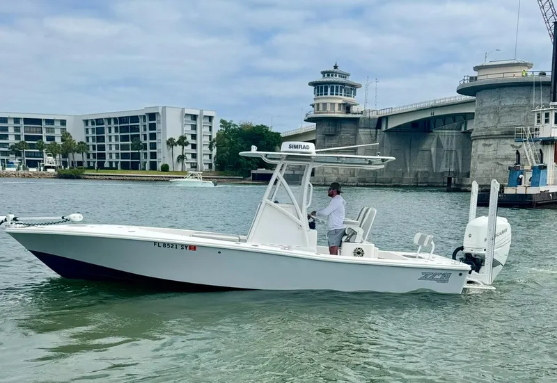 Slide: The Image of 2022 ZCB 26 Freemason boat cruising near a bridge and modern buildings. - 11